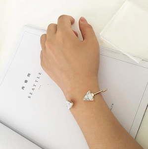 Detailed view of an open cuff bracelet with marble-patterned triangle stones on wrist
