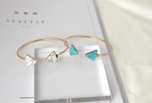 Detail of gold-plated alloy open bangles featuring marble texture triangle turquoise stones
