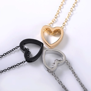 Three minimalist hollow heart necklaces in gold, black, and silver stainless steel finishes