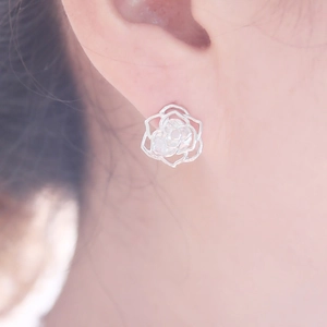 Gros plan d'élégantes boucles d'oreilles roses creuses en argent avec des zircons