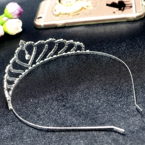 Detailed close-up of a silver crown headband featuring a central heart-shaped rhinestone