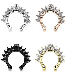 Close-up of four colored faux nose rings with rhinestones in silver, gold and black