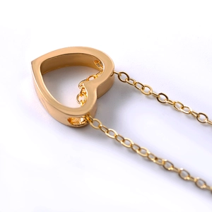 Macro shot of gold-plated hollow heart pendant necklace with intricate 3D structure