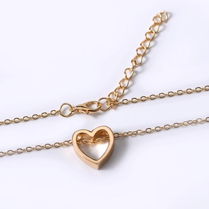 Macro view of gold hollow heart pendant necklace with lobster clasp and extension chain
