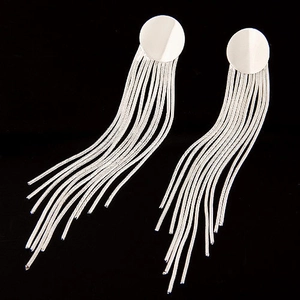 Silver tassel drop earrings with polished round studs on a minimalist black background