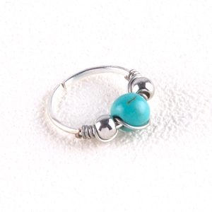 Detail of silver nose ring with turquoise bead and decorative wire wrap craftsmanship
