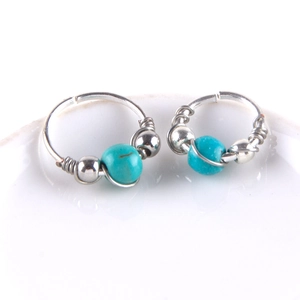 Macro view of bohemian silver wire wrapped earrings with vibrant turquoise beads