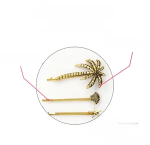 Detail of retro gold hair clips set with coconut tree, shell, and starfish shapes