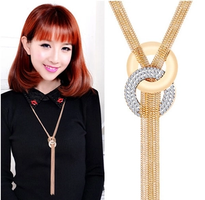 Detailansicht einer langen goldfarbenen Pulloverkette mit Doppelringen und Glitzerquasten