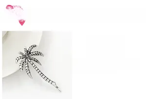 Detail of silver palm tree hair clip with vintage oxidized texture and summer style