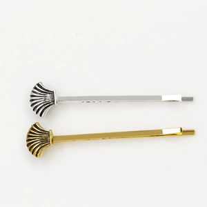 Shell shaped hair clip set in gold and silver finish with textured seashell design