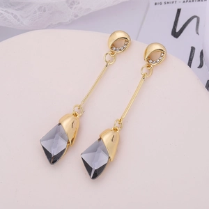Detail of drop earrings with grey crystal pendants and gold-tone rhinestone studs