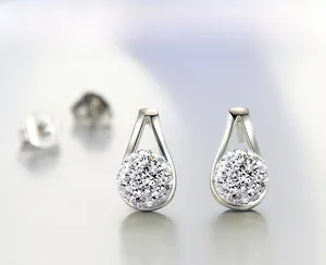 Close-up of silver-toned Shamballa style rhinestone ball earrings with triangular stud