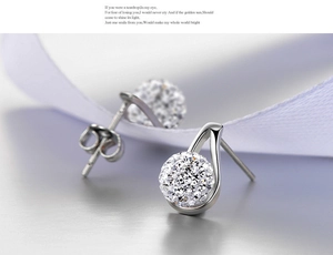 Macro detail of hollow teardrop earrings with sparkling crystal-encrusted pave balls
