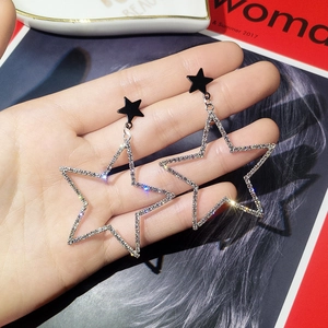 Détail macro de boucles d'oreilles étoile surdimensionnées avec strass étincelants et clous