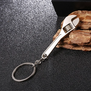 Macro shot of silver adjustable wrench keychain on a black textured background
