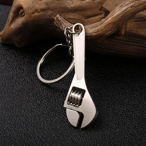 Creative adjustable wrench keychain in matte silver metal finish on a premium leather base