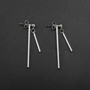 Détail macro de boucles d'oreilles géométriques en argent avec double barre polie