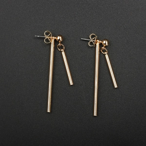 Détails des boucles d'oreilles géométriques dorées avec barres verticales sur fond noir