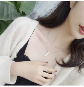 Close-up of minimalist double-layer necklace with geometric circle and bar pendants
