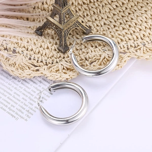 Nahaufnahme silberner Chunky Hoop-Ohrringe mit poliertem Finish und modernem Metalldesign