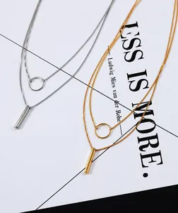 Detail of double-layer necklace featuring geometric circle and vertical bar pendants