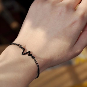 Minimalist black lightning heartbeat bracelet for women worn on wrist in natural light