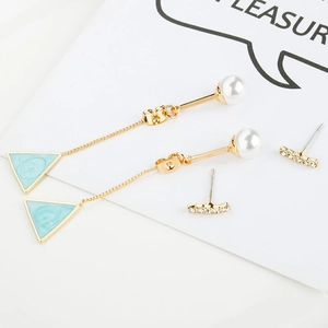 Detail of elegant pearl triangle drop earrings and sparkling stud earrings set