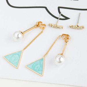 Macro view of pearl drop earrings with green triangle and crystal bar studs