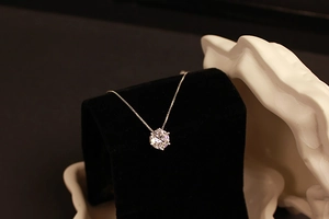 Close-up of six-prong solitaire zircon pendant necklace on black velvet display
