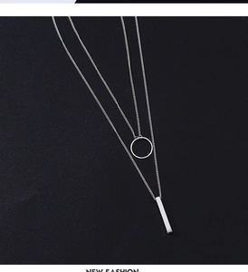 Detail view of silver double-layered necklace with round and vertical bar geometric pendants