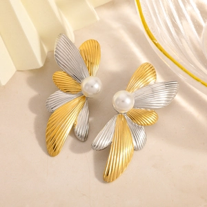 Macro detail of two-tone petal earrings featuring white pearls and metallic textures