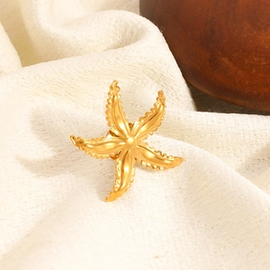 Minimalist 18K gold plated starfish brooch with matte finish on textured fabric