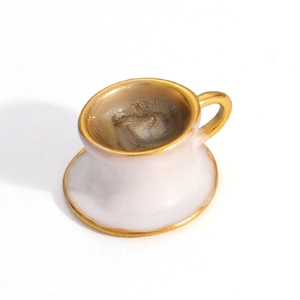 Detailed top view of a miniature white coffee cup with gold rim and brown glitter detail