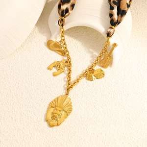 Detail of bohemian gold necklace with leopard scarf and western themed charms