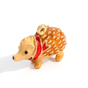 Macro view of a 3D hedgehog pendant with orange enamel and gold plated alloy details
