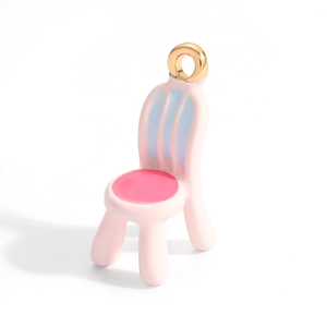 Macro detail of creative pink chair alloy pendant with blue stripes and gold loop