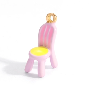 Detailed close-up of a pink and yellow enamel chair charm with gold plating for jewelry