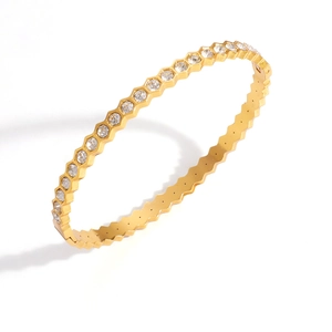 Détail d'un bracelet jonc hexagone doré serti de pierres de zircon claires brillantes