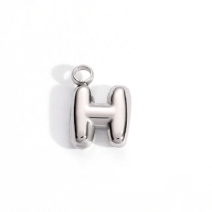 Macro view of bubble style letter H pendant in polished silver stainless steel