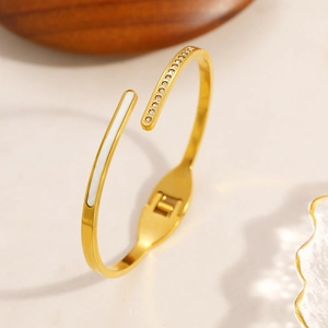 Vue détaillée du bracelet doré avec incrustation blanche et sertissage de strass brillants