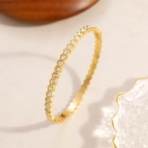 Détail du bracelet en acier inoxydable doré avec hexagones et pierres incrustées