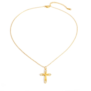 Macro detail of gold plated stainless steel cross pendant with sparkling zircon accents