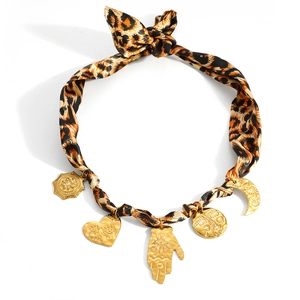 Leopard print fabric necklace featuring five gold evil eye pendants with moon and heart