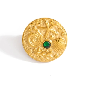 Goldene Ozean-Brosche mit geprägten Muscheln, Seestern und grünem Edelstein im Fokus