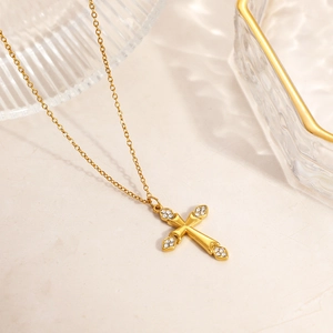 Close-up of gold cross pendant with sparkling zircon accents on O-chain necklace