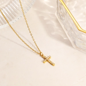 Close-up of gold-plated 18K stainless steel necklace featuring a crystal cross pendant