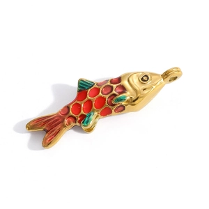 Macro detail of a fish-shaped pendant with colorful red enamel scales and gold finish
