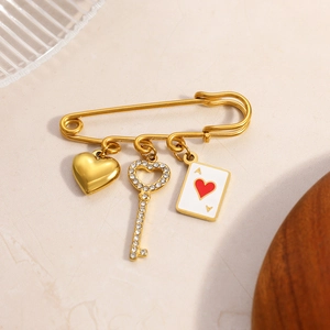 Detailed close-up of 18K gold-plated brooch with heart, key, and Ace of Hearts charms