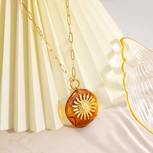 Collana in acciaio inossidabile placcato oro 18K con rilievo solare su ciondolo ambra